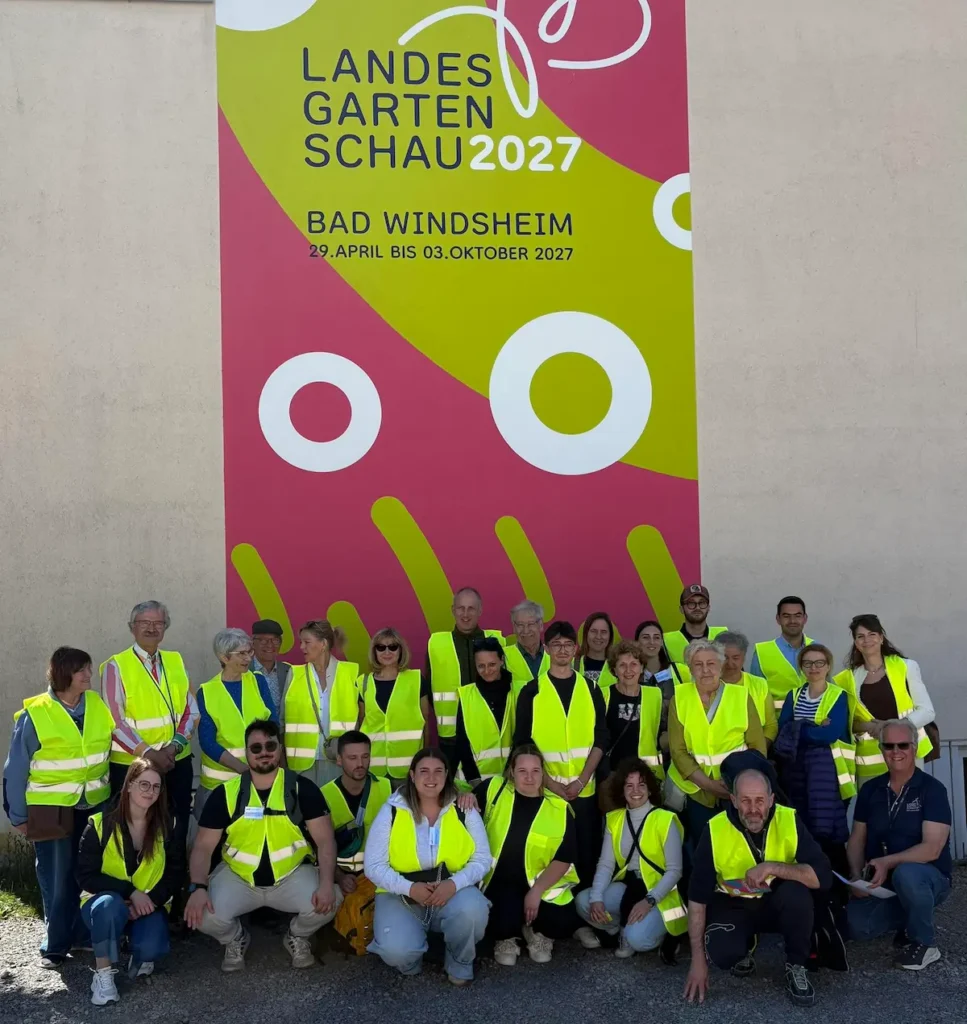 Gruppenfoto von mehreren Personen in gelber Warnweste vor einem großen Landesgartenschau Banner